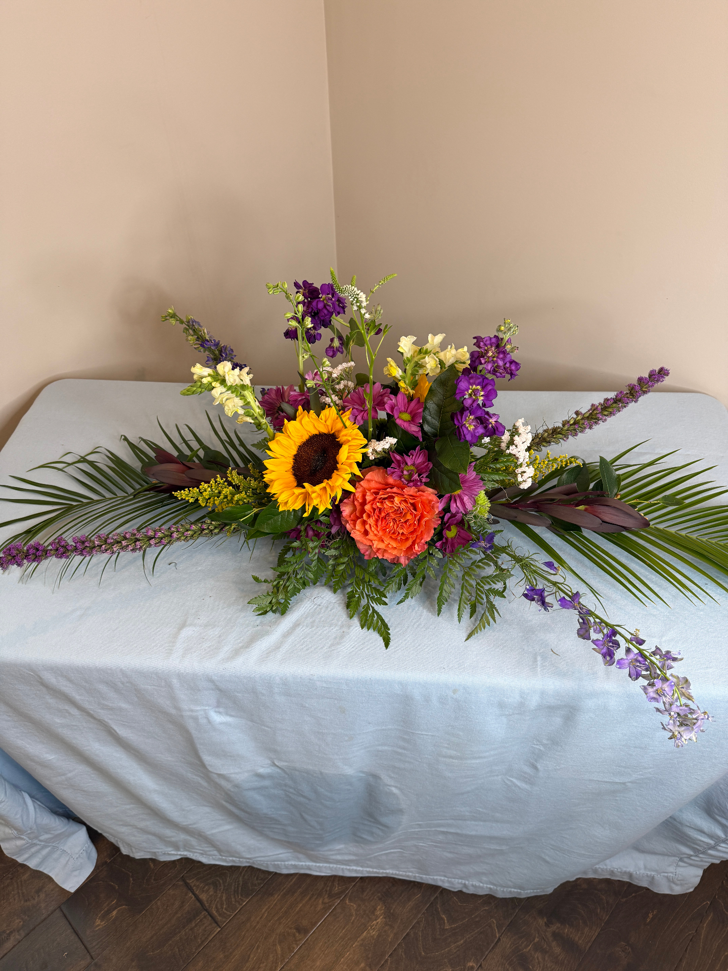 Sunflower, snapdragon, and purple stock milestone centerpiece by Dolce Flowers in Greenville, SC